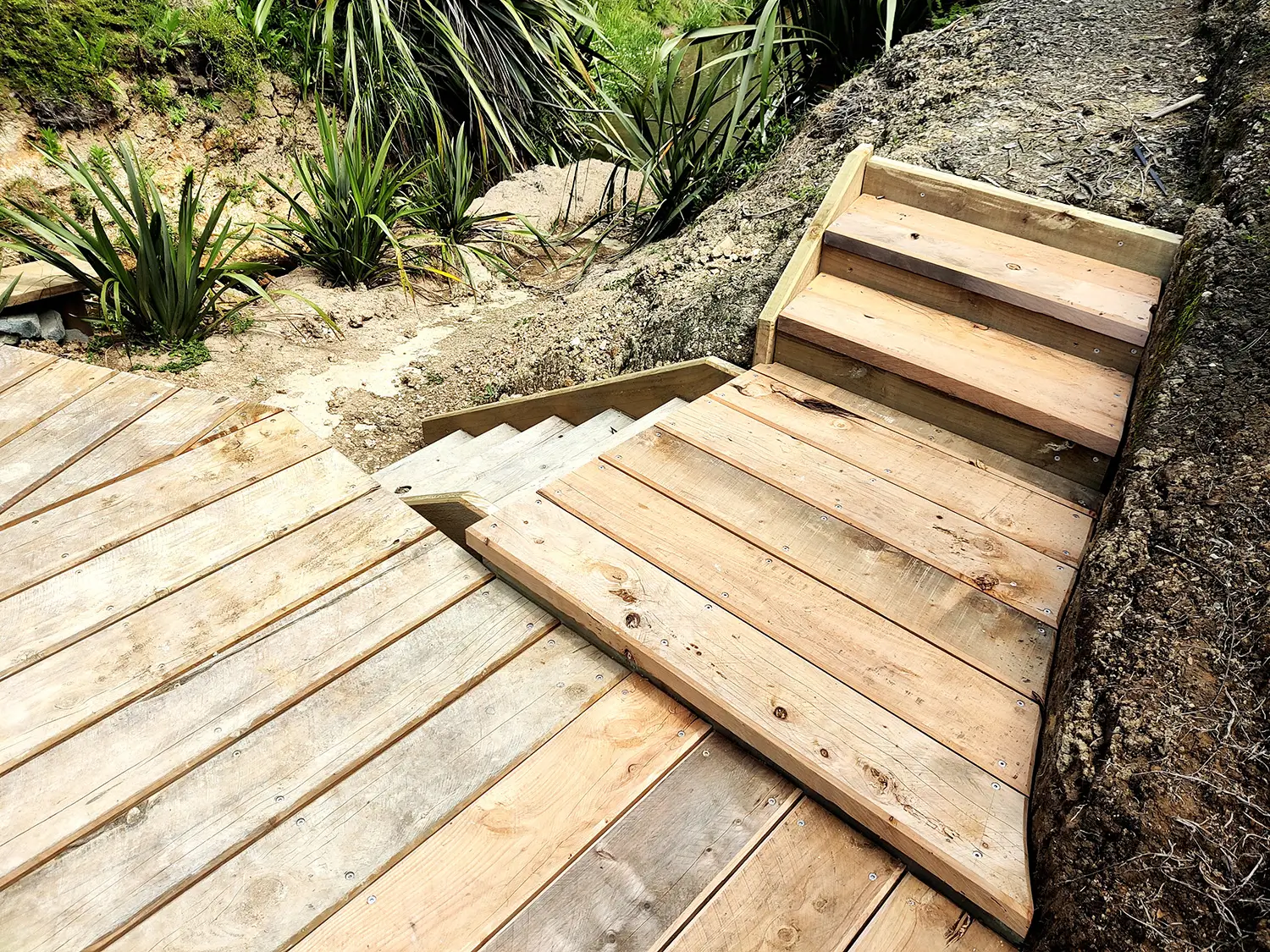 Timber steps leading down to the rebuilt bridge