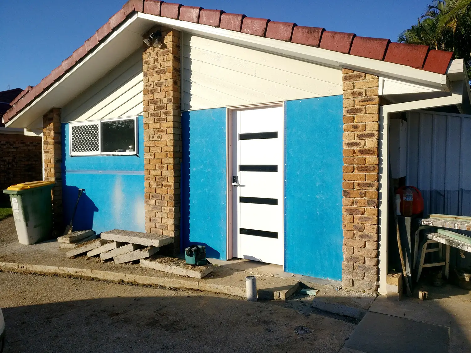 The garage exterior, mid-conversion with new door and cladding